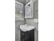 Bathroom vanity area with black cabinet, window, and mirrored medicine cabinet at 8644 Roanoke Dr, North Charleston, SC 29406