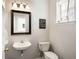 Cozy half bathroom featuring a white vessel sink, dark framed mirror, and natural light at 8986 N Red Maple Cir, Summerville, SC 29485