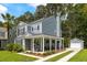 Beautiful home with a covered front porch, inviting rocking chairs, and a detached garage at 8986 N Red Maple Cir, Summerville, SC 29485