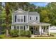 Charming two-story home with a covered front porch, manicured lawn, and a lush palm tree at 8986 N Red Maple Cir, Summerville, SC 29485