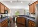 Modern kitchen with stainless steel appliances, wood cabinetry, and an adjacent dining area at 8986 N Red Maple Cir, Summerville, SC 29485