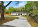 Inviting white home surrounded by lush trees, featuring a well-manicured lawn and a long, winding driveway at 920 Julia St, Charleston, SC 29412
