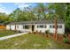 Charming single-story home with a well-manicured lawn and a cozy front porch and mature trees at 920 Julia St, Charleston, SC 29412