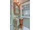 Charming bathroom featuring a bamboo mirror, patterned wallpaper, and vintage-style fixtures at 95 Ashley Ave # D, Charleston, SC 29401