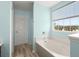 Bright bathroom featuring a bathtub and a window with a view to the outside at 9731 Stockport Cir, Summerville, SC 29485