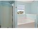 Bright bathroom featuring a shower and tub combo and window with a view to the outside at 9731 Stockport Cir, Summerville, SC 29485