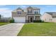 Two-story home featuring a two-car garage, manicured lawn, and a welcoming front porch entry at 9731 Stockport Cir, Summerville, SC 29485