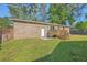 Expansive backyard with mature trees, a deck, and brick exterior creating a private outdoor retreat at 100 Lipman St, Summerville, SC 29483