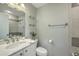 Well-lit bathroom features gray and white tiling, updated fixtures, and glass shelving for ample storage at 100 Lipman St, Summerville, SC 29483