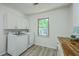 Well-lit laundry room with storage cabinets, butcher block counters, and updated appliances at 100 Lipman St, Summerville, SC 29483