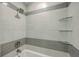 Updated shower with white and gray tile, a rainfall showerhead, and glass shelves for added convenience at 100 Lipman St, Summerville, SC 29483