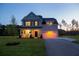 Charming two-story home with inviting front porch and attached garage at dusk at 10032 Randall, McClellanville, SC 29458