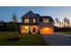 Charming two-story home with inviting front porch and attached garage at dusk at 10032 Randall, McClellanville, SC 29458