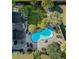 Aerial view of a landscaped backyard with a swimming pool, patio, and lush greenery at 101 Writing Ct, Ladson, SC 29456