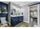 Bathroom with dual sinks, blue vanity, wood floors, and an open view into the bedroom at 101 Writing Ct, Ladson, SC 29456