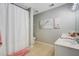 Clean bathroom featuring floral-themed decor, white fixtures, and a shower-tub combination at 101 Writing Ct, Ladson, SC 29456
