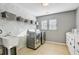 Well-lit laundry room features modern appliances, a utility sink, and ample storage space on shelving above at 101 Writing Ct, Ladson, SC 29456