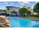 Private backyard oasis with rock waterfall feature flowing into a sparkling in-ground pool at 101 Writing Ct, Ladson, SC 29456