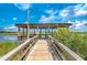 Picturesque wooden dock with covered structure over the water, showcasing serene waterfront views at 104 Tidewater Way, Charleston, SC 29492