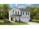 Charming two-story home with light blue siding, a welcoming front porch and attached two-car garage at 1055 Tea Time Dr, Summerville, SC 29485