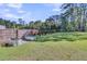 A spacious backyard with lush lawn, wooden fence, garden beds, and mature trees at 106 Lakelyn Rd, Moncks Corner, SC 29461