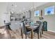 An open dining area features wood floors, a chandelier, seating for six, and access to the kitchen with gray cabinets at 106 Lakelyn Rd, Moncks Corner, SC 29461