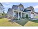 Charming two-story home with a inviting front porch, stone accents, and lush landscaping at 106 Lakelyn Rd, Moncks Corner, SC 29461