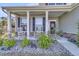 Inviting front porch with white columns, rocking chairs, and stone accents, offering a cozy welcome at 106 Lakelyn Rd, Moncks Corner, SC 29461
