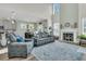 Bright living room boasts a fireplace, high ceilings, and comfortable gray sofa and armchairs at 106 Lakelyn Rd, Moncks Corner, SC 29461