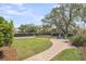 Landscaped backyard featuring a brick pathway, firepit, and well-manicured lawn at 1063 Hills Plantation Dr, Charleston, SC 29412