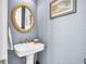 Stylish powder room with decorative mirror, pedestal sink, and blue walls at 1063 Hills Plantation Dr, Charleston, SC 29412