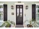 Elegant front door with black trim, decorative lights, and potted plants at 1063 Hills Plantation Dr, Charleston, SC 29412