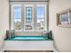 Window seat featuring three large windows with blue cushion and decorative pillows at 1063 Hills Plantation Dr, Charleston, SC 29412