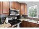 Updated kitchen with wood cabinetry, stainless steel appliances, and tiled backsplash at 108 Smith St # 108-I, Charleston, SC 29403