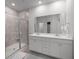 Bright bathroom featuring double vanity sinks, neutral tile flooring, and a glass-enclosed shower at 110 Haverhill St, Summerville, SC 29486