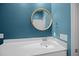 Stylish bathroom with a blue wall, round mirror, and white vanity at 110 Haverhill St, Summerville, SC 29486