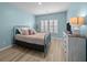 Cozy bedroom with blue walls, shuttered windows, and light wood flooring at 110 Haverhill St, Summerville, SC 29486