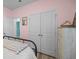 Bedroom featuring a black iron bed frame, soft bedding, and a closet with classic white doors, and a pink accent wall at 110 Haverhill St, Summerville, SC 29486