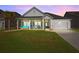 Inviting exterior with a front porch swing, rocking chairs, and a two-car garage at sunset at 110 Haverhill St, Summerville, SC 29486