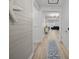 Bright hallway featuring shiplap walls, wood floors, and a blue rug leading to the living room at 110 Haverhill St, Summerville, SC 29486