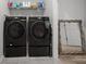 Well-lit laundry room with modern, front-loading washer and dryer set and wire shelving for storage at 110 Haverhill St, Summerville, SC 29486