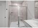 Modern shower with gray tiling, glass door, and built-in corner shelf at 110 Haverhill St, Summerville, SC 29486