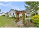 Landscaped backyard with an arbor leading to a garden and well maintained lawn at 113 Sugarberry Way, Summerville, SC 29485
