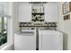 Clean laundry room with modern washer and dryer, shaker cabinets, floating shelves and ample lighting at 113 Sugarberry Way, Summerville, SC 29485