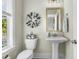 Charming powder room featuring a pedestal sink, decorative mirror, and modern fixtures at 113 Sugarberry Way, Summerville, SC 29485