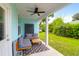 Cozy back porch with gray couches, wooden table, outdoor décor, and a view of the green backyard at 1130 5Th Ave, Charleston, SC 29407