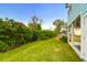 Green backyard featuring mature trees, lush grass, and view of the home's exterior and covered porch at 1130 5Th Ave, Charleston, SC 29407
