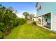 Lush backyard featuring mature trees, green grass, and view of the home's exterior and covered porch at 1130 5Th Ave, Charleston, SC 29407