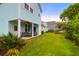 Lush backyard with green grass, mature trees, and a covered porch for outdoor living at 1130 5Th Ave, Charleston, SC 29407
