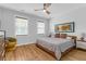 Comfortable bedroom features a ceiling fan, natural light, hardwood floors and modern decor at 1130 5Th Ave, Charleston, SC 29407